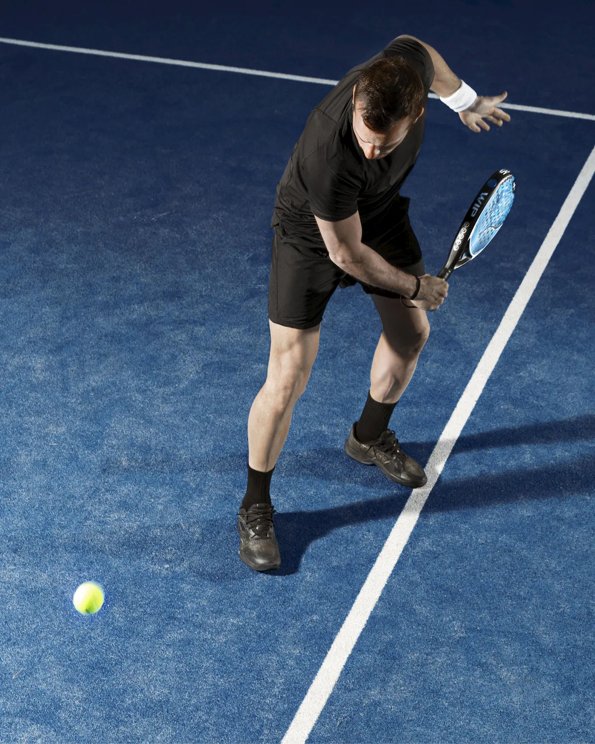 Jugador de pádel preparando el golpe junto a la línea de saque